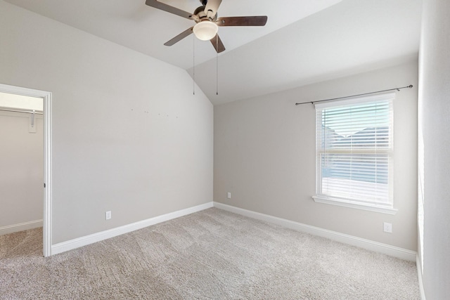 spare room featuring ceiling fan, vaulted ceiling, and light carpet