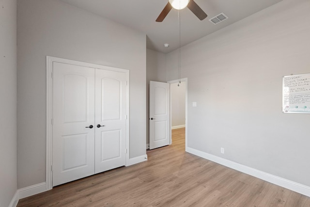 unfurnished bedroom featuring light hardwood / wood-style floors, a closet, and ceiling fan