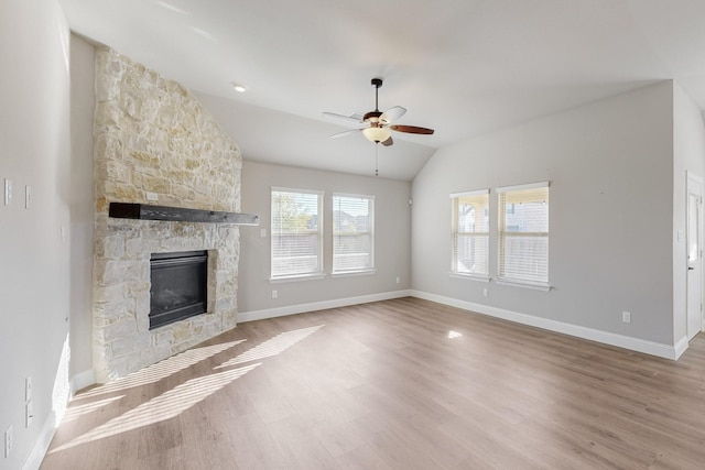 unfurnished living room featuring ceiling fan, lofted ceiling, a fireplace, and light hardwood / wood-style floors