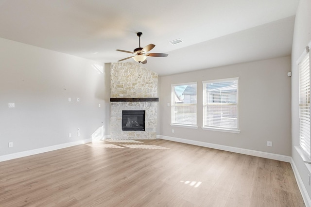 unfurnished living room with a fireplace, light hardwood / wood-style floors, ceiling fan, and vaulted ceiling