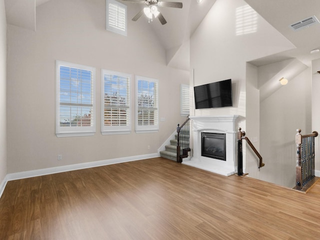 unfurnished living room featuring hardwood / wood-style flooring, high vaulted ceiling, and ceiling fan