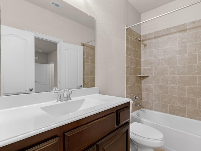 full bathroom with tiled shower / bath combo, toilet, and vanity