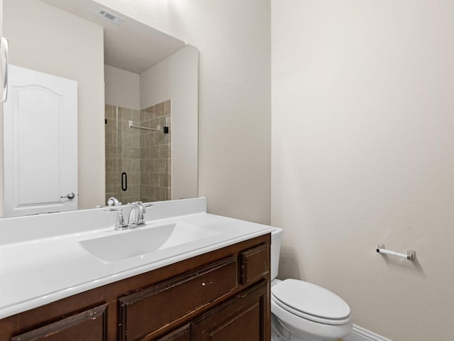 bathroom featuring vanity, an enclosed shower, and toilet