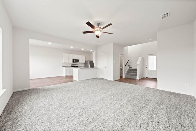 unfurnished living room with light hardwood / wood-style flooring and ceiling fan