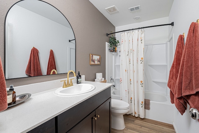 full bathroom featuring vanity, toilet, wood-type flooring, and shower / tub combo