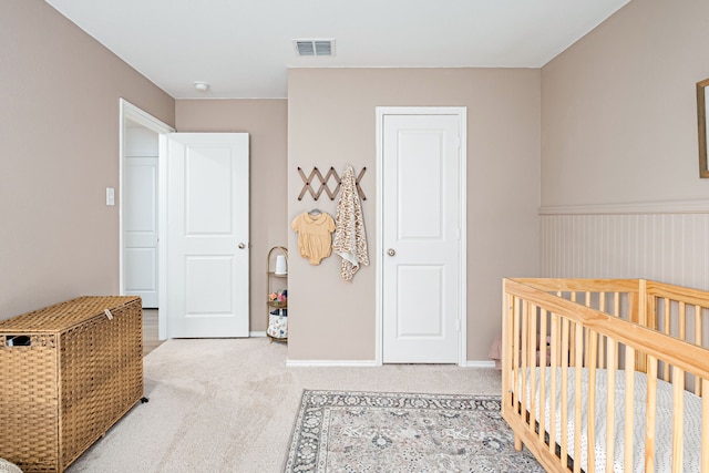 carpeted bedroom with a nursery area