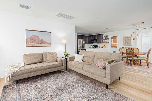 living room with hardwood / wood-style flooring and a notable chandelier