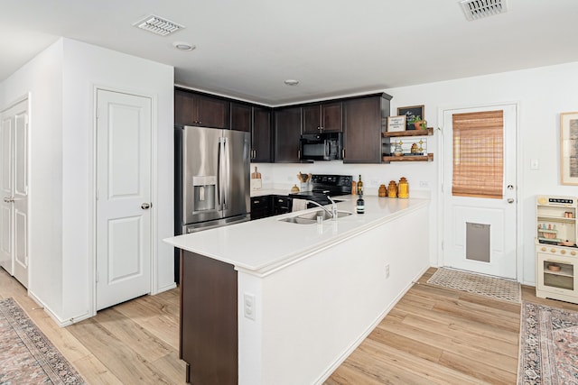 kitchen with sink, light hardwood / wood-style flooring, kitchen peninsula, dark brown cabinets, and black appliances