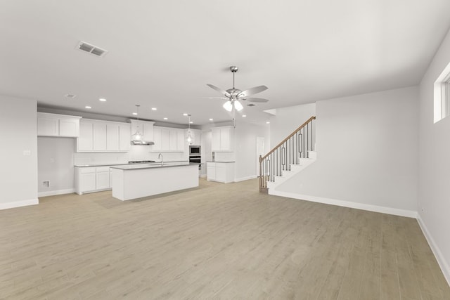 unfurnished living room with light wood-style flooring, a ceiling fan, visible vents, recessed lighting, and baseboards
