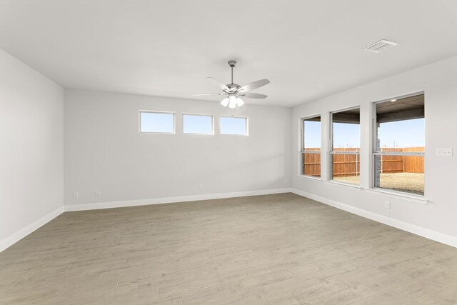 unfurnished room featuring visible vents, ceiling fan, light wood-style floors, and baseboards