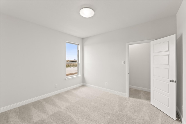 carpeted empty room with baseboards