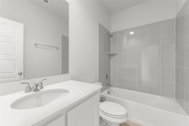 full bathroom with bathing tub / shower combination, vanity, visible vents, and toilet