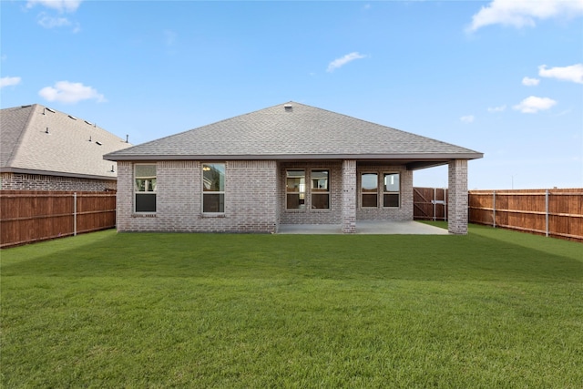 back of house with brick siding, a fenced backyard, a lawn, and a patio area