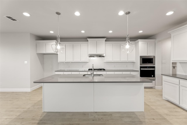 kitchen featuring tasteful backsplash, wall oven, visible vents, under cabinet range hood, and stainless steel microwave