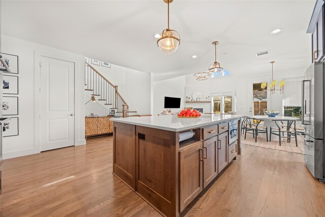 entryway with a large fireplace, a chandelier, a high ceiling, and hardwood / wood-style flooring