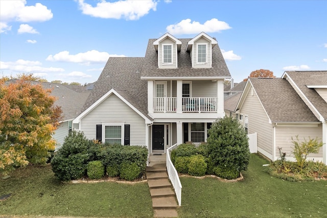 view of front of property with a balcony and a front yard