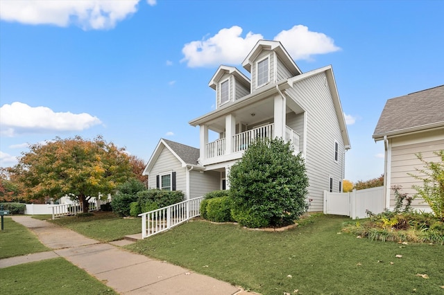 view of front of property with a balcony and a front lawn