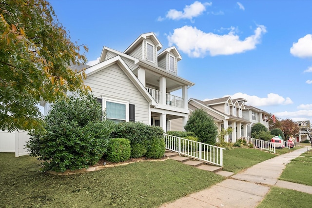 view of front of home featuring a balcony and a front yard