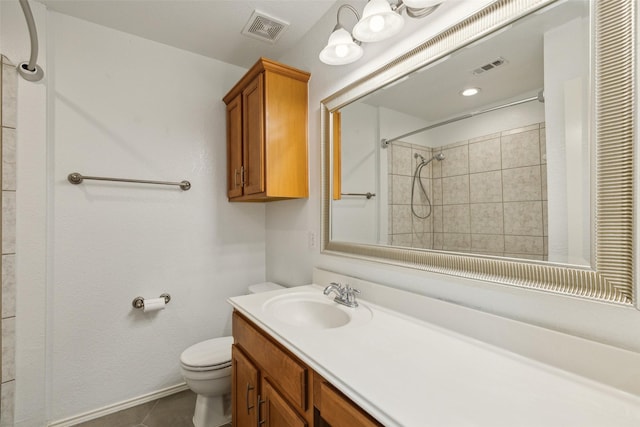 bathroom with tile patterned floors, vanity, toilet, and a tile shower