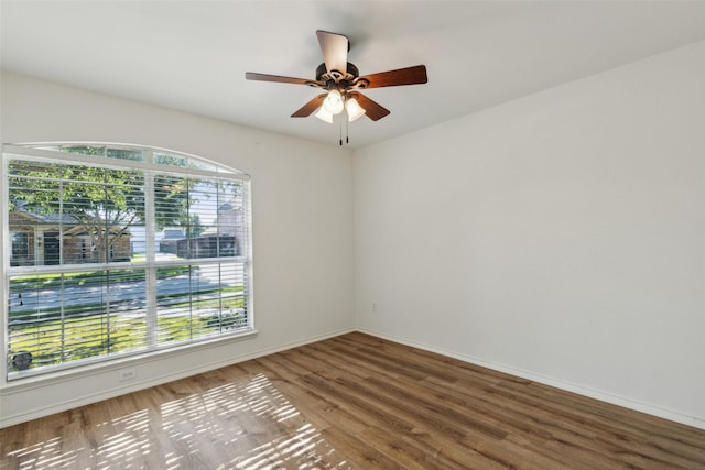 empty room with hardwood / wood-style flooring, ceiling fan, and a healthy amount of sunlight