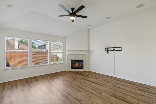 unfurnished living room with hardwood / wood-style floors, a healthy amount of sunlight, and lofted ceiling