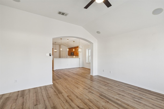 unfurnished living room with ceiling fan, light hardwood / wood-style floors, and lofted ceiling