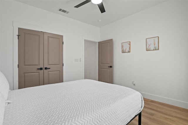 bedroom featuring hardwood / wood-style flooring, ceiling fan, and a closet