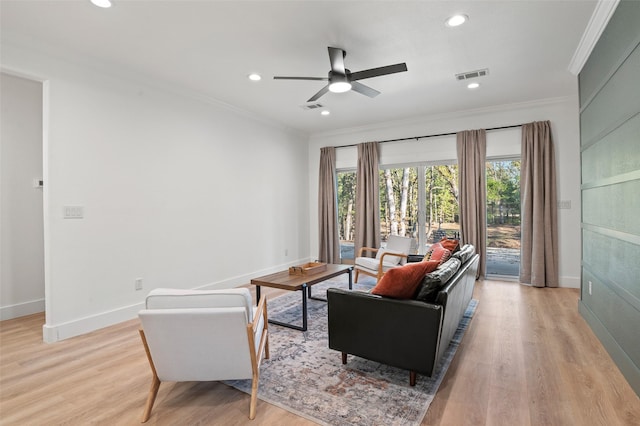 living room featuring light hardwood / wood-style floors, ceiling fan, and crown molding