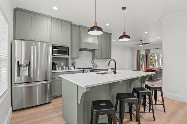 kitchen with pendant lighting, sink, a kitchen breakfast bar, decorative backsplash, and stainless steel appliances