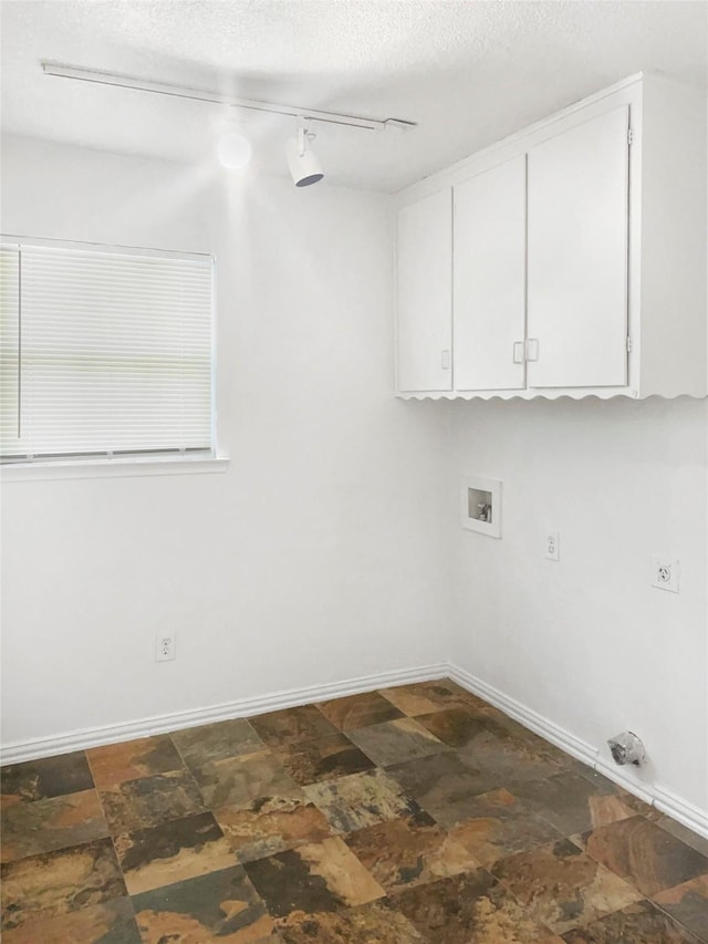2649 Peavy Rd, Dallas, TX 75228 - laundry area featuring cabinet space, rail lighting, dark stone finish floors, hookup for a washing machine, and a textured ceiling