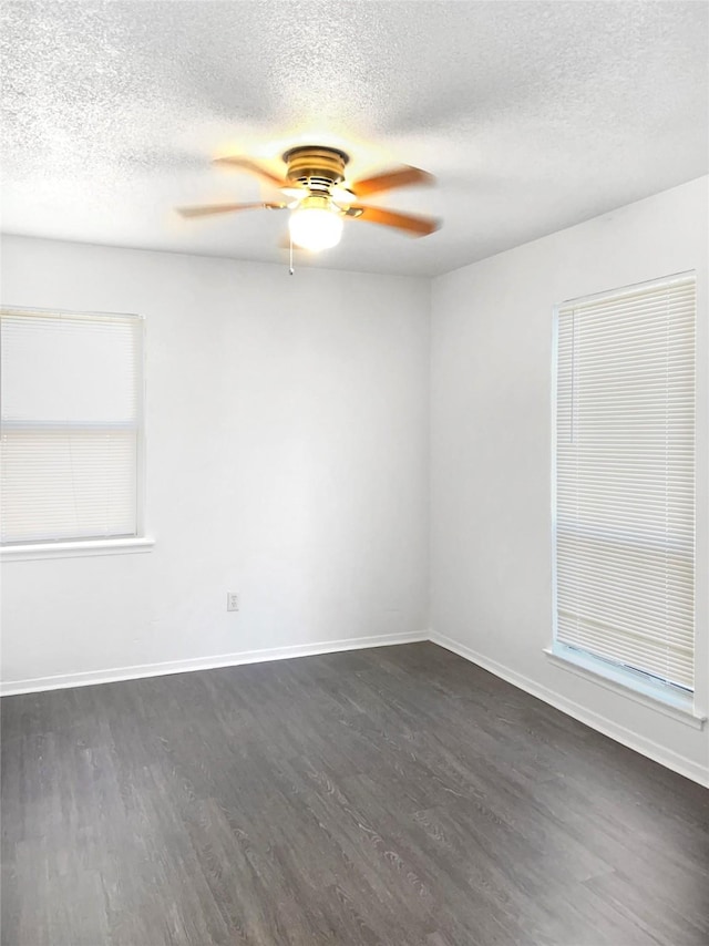 unfurnished room with a textured ceiling and dark wood-type flooring