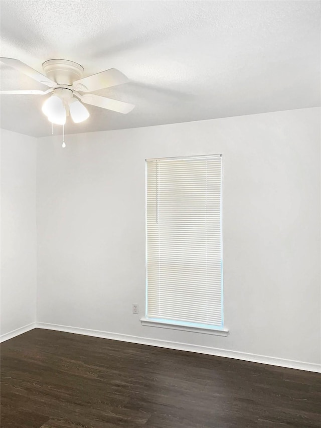 spare room featuring a textured ceiling, ceiling fan, and dark wood-type flooring