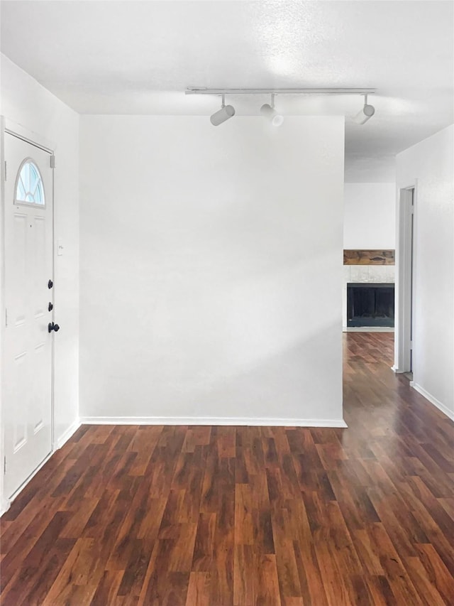 entryway with a stone fireplace and dark hardwood / wood-style floors