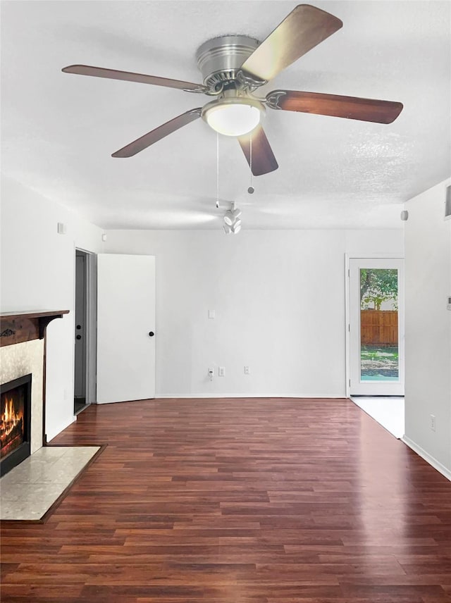 unfurnished living room featuring a textured ceiling, a high end fireplace, dark hardwood / wood-style floors, and ceiling fan