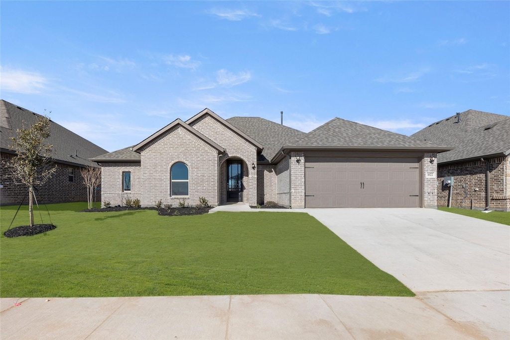 french provincial home with a garage and a front yard