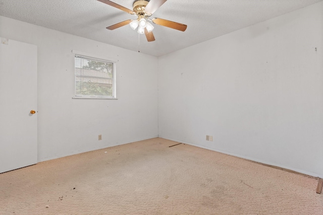 carpeted empty room with ceiling fan and a textured ceiling