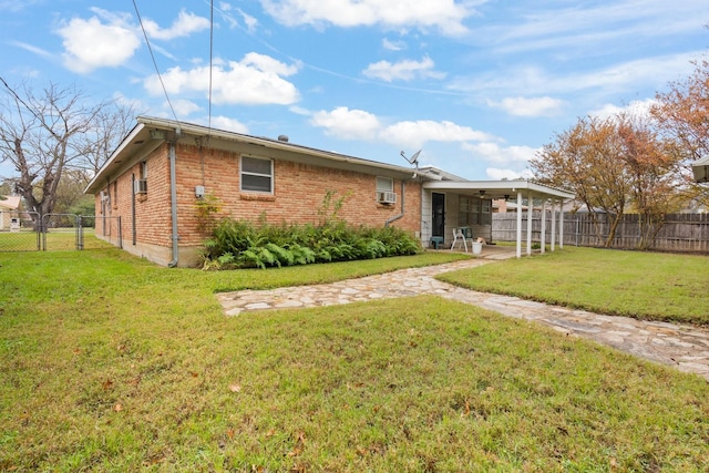 rear view of house with a lawn and a carport