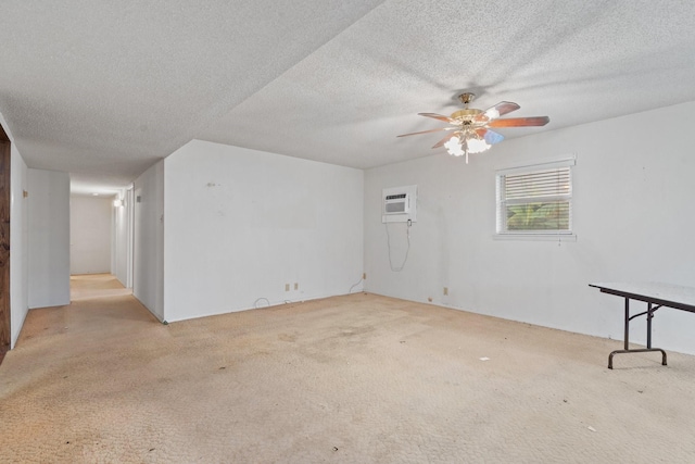 unfurnished room featuring ceiling fan, light colored carpet, an AC wall unit, and a textured ceiling