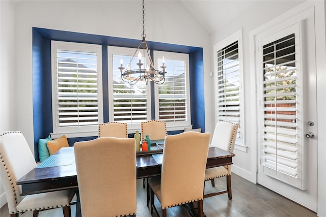 dining space featuring vaulted ceiling, wood-type flooring, and an inviting chandelier