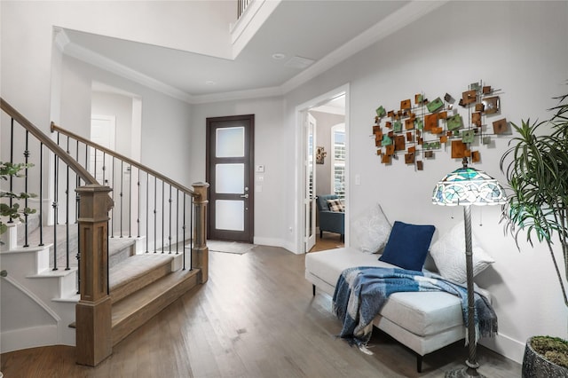 entryway with ornamental molding and hardwood / wood-style flooring