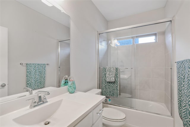 full bathroom featuring vanity, shower / bath combination with glass door, and toilet