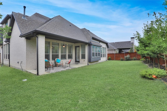 rear view of property with a yard and a patio