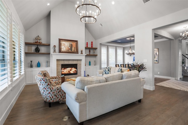 living room with a notable chandelier, built in features, high vaulted ceiling, and dark hardwood / wood-style floors