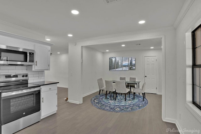 kitchen featuring stainless steel appliances, white cabinetry, crown molding, and light hardwood / wood-style flooring