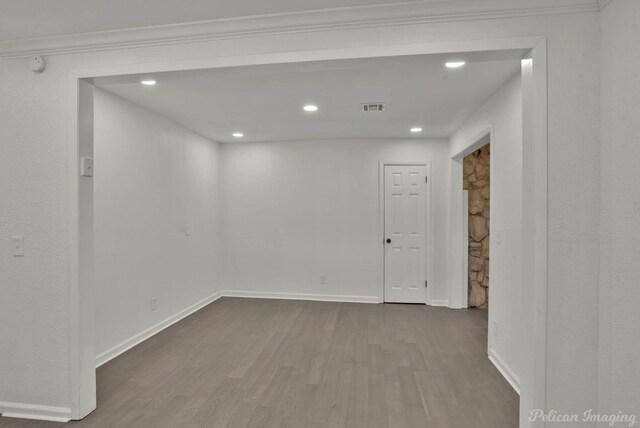 spare room with hardwood / wood-style flooring and crown molding