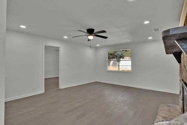 unfurnished living room with ceiling fan and dark wood-type flooring