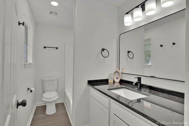 bathroom featuring wood-type flooring, vanity, and toilet