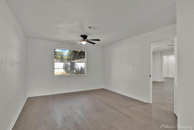 empty room with ceiling fan and light hardwood / wood-style floors