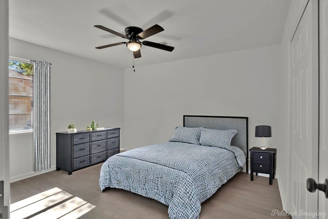 bedroom with light hardwood / wood-style floors and ceiling fan