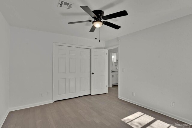 unfurnished bedroom featuring ceiling fan, a closet, and light wood-type flooring